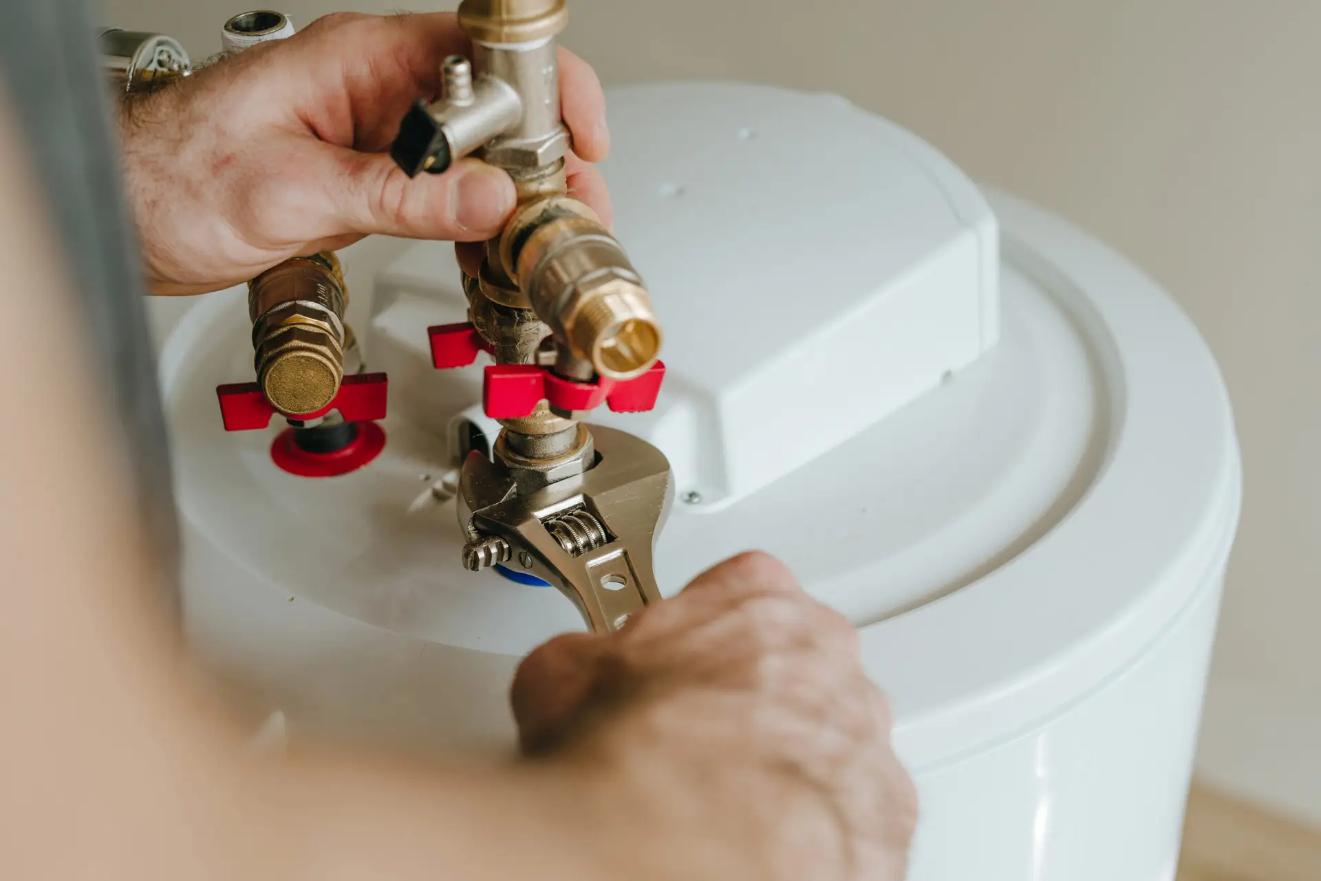 Experienced plumber installing a fitting for a water heater